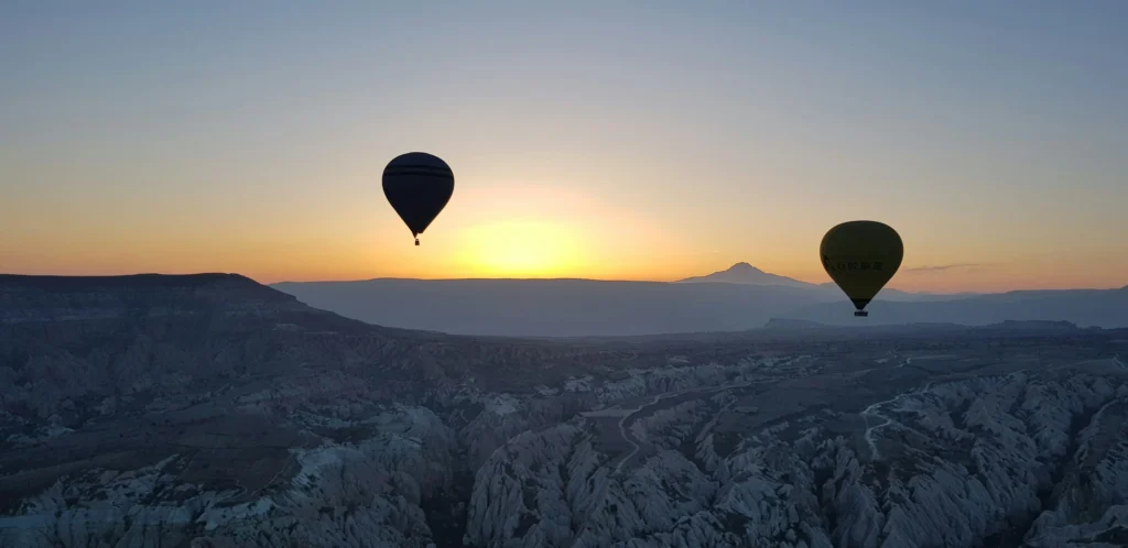 Montgolfière survolant un lever de soleil.